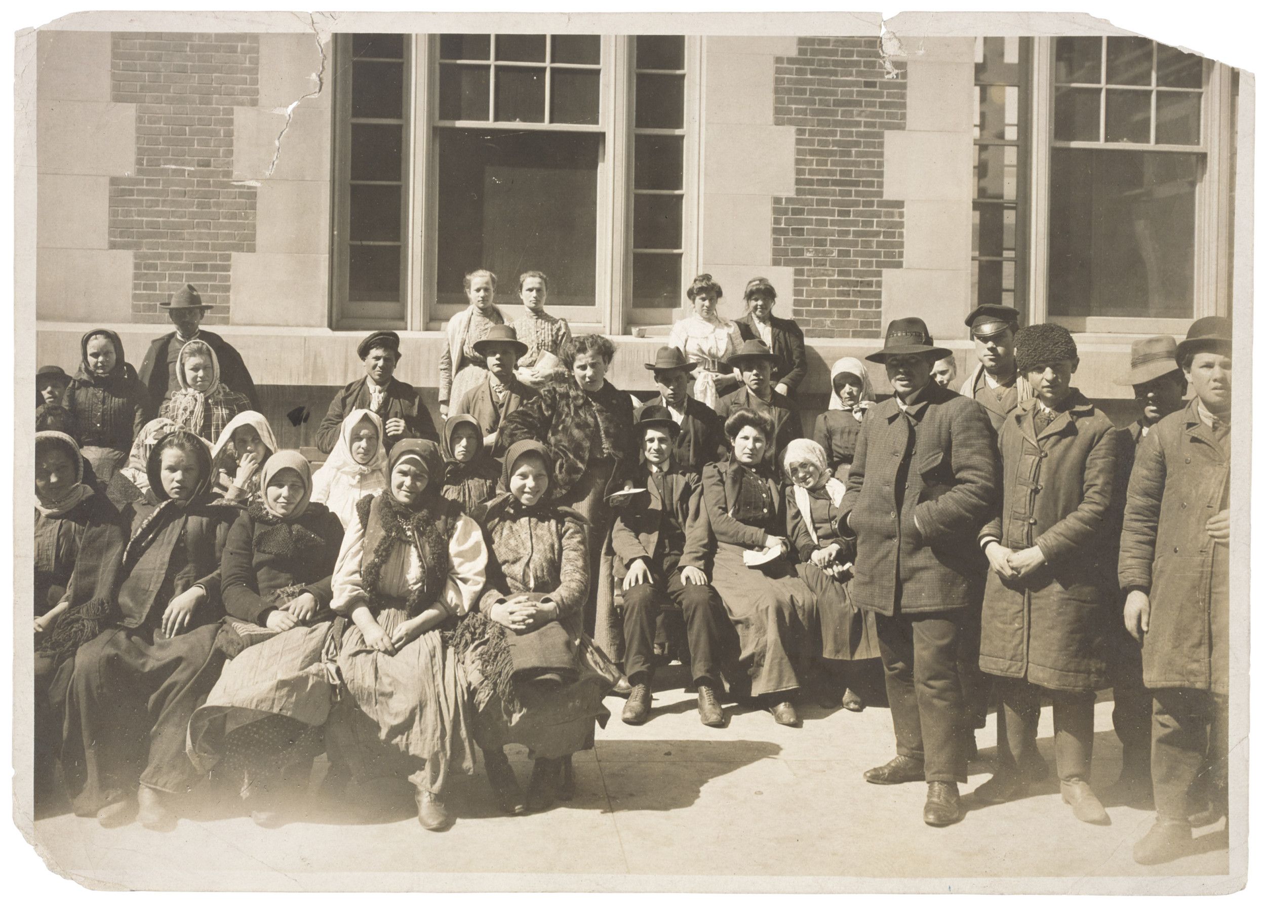A Group of Immigrants Outside a Building on Ellis Island